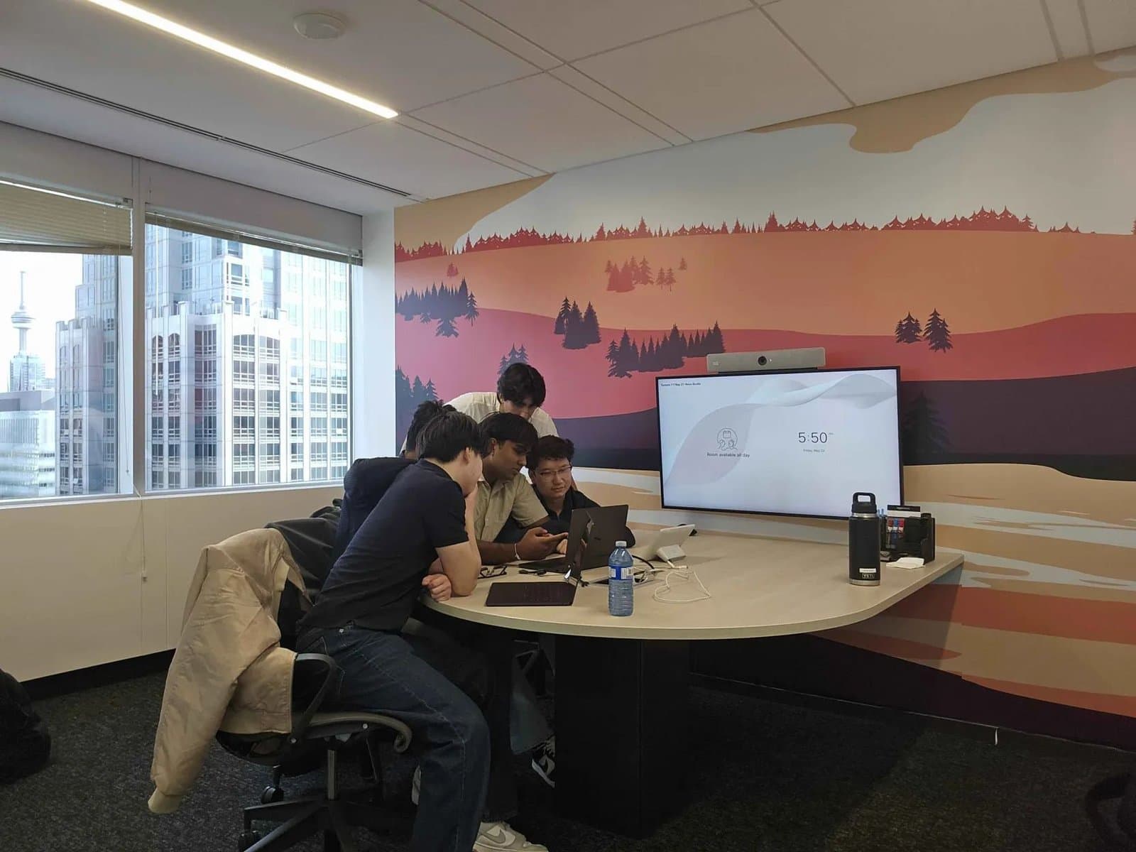 Team members gathered around a laptop during a working session at RBC Borealis.